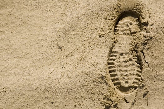 single footprint impression in the desert sand on right of image