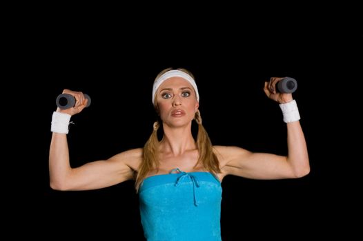 Woman exercising with weights against a black background