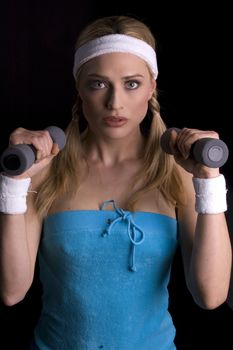 Woman doing exercise weith weights over a black backgound