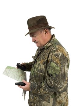 Man in Camouflage clothing using national forest maps and two gps's to check position on a white background