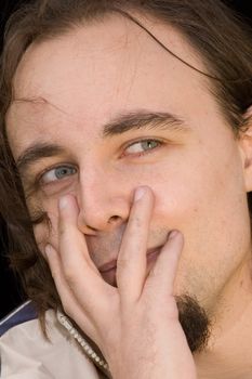 young man with green eyes and beard over black