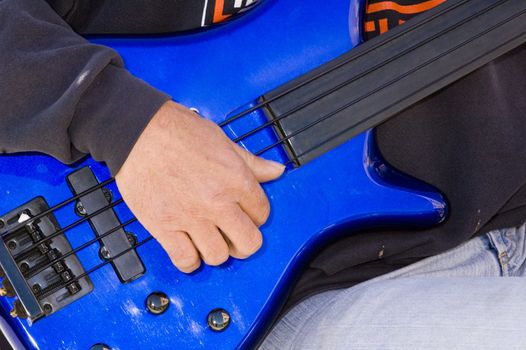 Guitarists hands playing instrument isolated on a white background while sitting on a stool