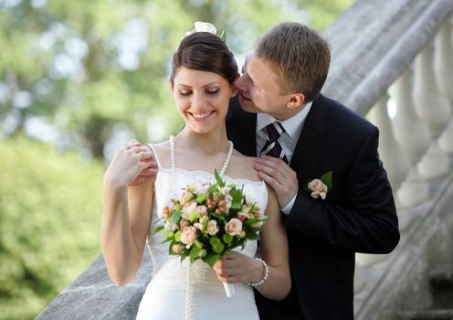 Happy newlywed young adult couple embracing outdoors.