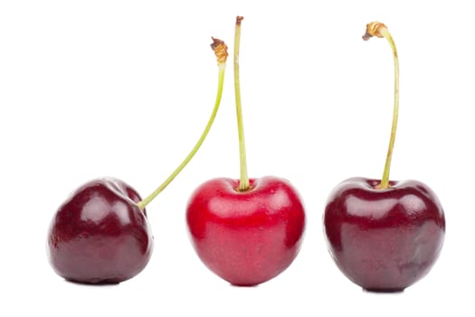 Close up view of three cherries isolated over white background