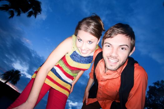 Young couple against a deep blue sunset 