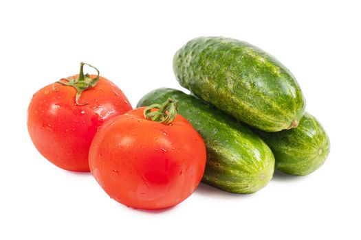 Fresh washed vegetables (cucumbers and tomatoes) over white background