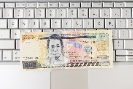Philippine money on computer keyboard