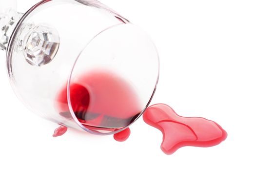 Red wine spilled from glass over white background