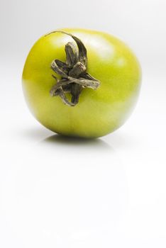 Green tomato shot against white background