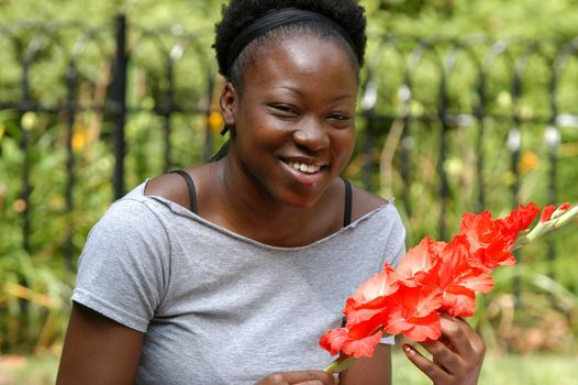 Young african american woman smiles while holding flowers