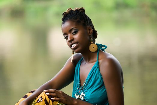 African American woman sits and relaxes by the river front