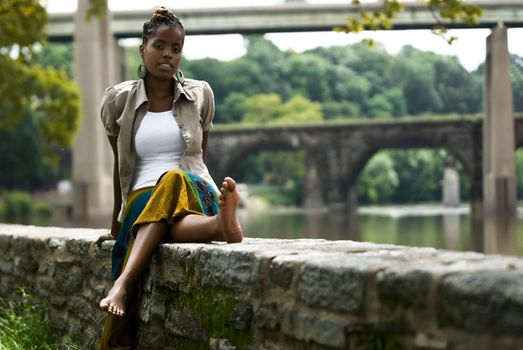 African American woman sits and relaxes by the river front