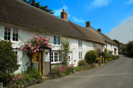 Row of pretty English traditional thatched country cottages in the small village of Abbotsbury in Dorset.