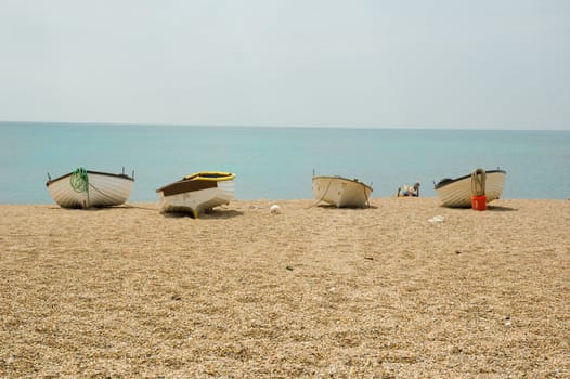 beach scene with a group of small boats on the gravel