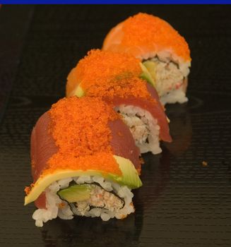 A series of sushi plates at an outdoor venue with a shallow depth of field