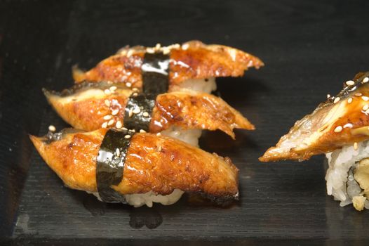 A series of sushi plates at an outdoor venue with a shallow depth of field