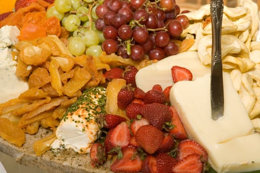 Assortment of fresh and dried fruits with a variety of cheeses
