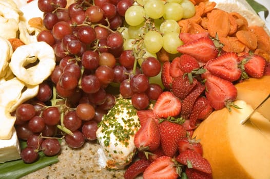 Assortment of fresh and dried fruits with a variety of cheeses