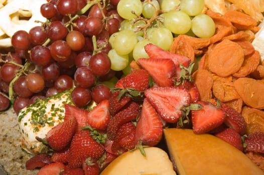 Assortment of fresh and dried fruits with a variety of cheeses