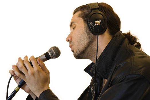 Profile of a young man in a leather jacket singing in a romantic way in a microphone.