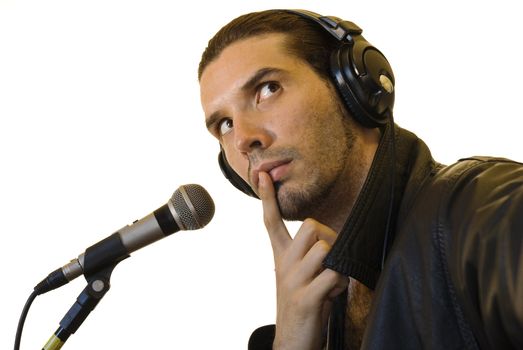Profile of a young man in a leather jacket in front of a microphone, thinking.