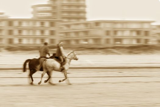 image of people riding horses in the beach