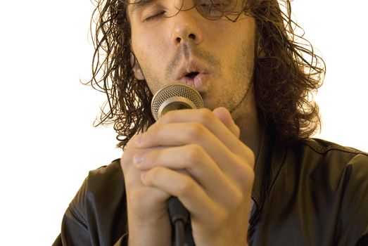 Portrait of a young man in a leather jacket singing in a romantic way in a microphone. Front shot