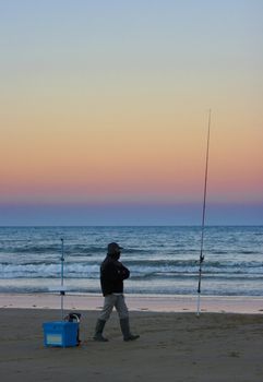 image of an angler and his tackle fishing from the beach