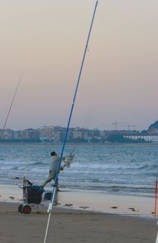 image of an angler and his tackle fishing from the beach