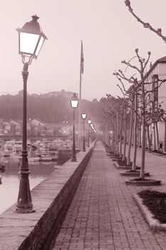 image of a long cold street with a line of lamppost