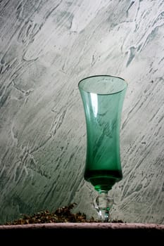 Green wine glass on a background to plaster