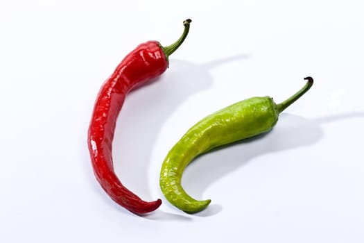 Green and red pepper on the white background