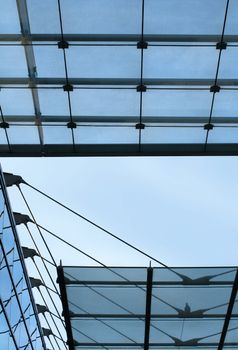 Detail of modern (2003) open glass ceiling consisting of three different levels. The lowest is hanging on steel cables. Copy space in the sky.