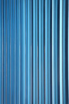 A shot of blue decorative glass tiles partitioning the windows of an office building's facade makes a great gradient background abstract. Vertical version.