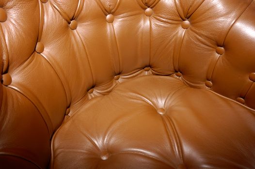 Close-up of a seat upholstered in rich brown leather.