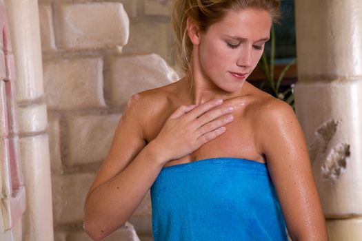 Pretty blond woman rubbing scrub salt on her skin