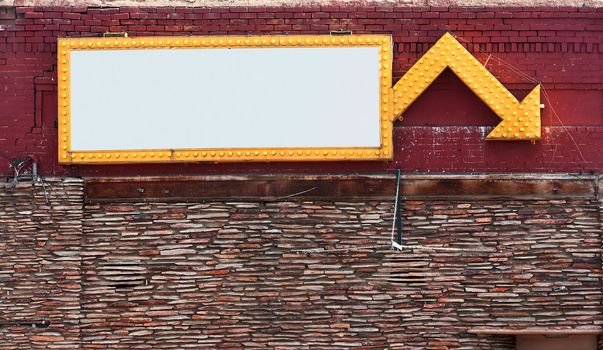 Blank sign surrounded with yellow lights on brick building