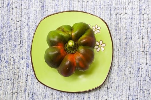 Big bell pepper on green saucer