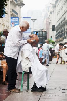 Chinese elders having their hair cut along Nanjing Road, Shanghai
