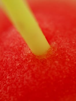 Yellow straw in red iced drink