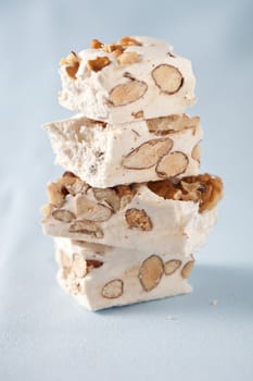 Few pieces of nougat stacked together on light blue background