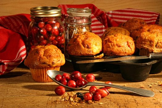 Delicious cranberry muffins with fresh berries on table