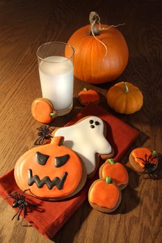 Halloween cookies with pumpkins and a glass of milk