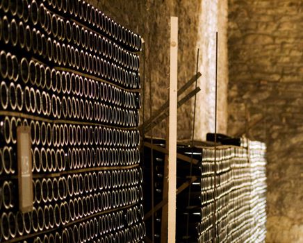 Closeup of bottles of wine aging in an old cellar