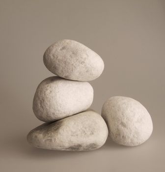 Four white pebbles over a gray background