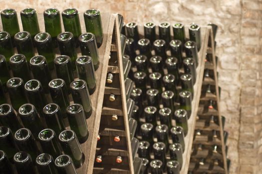 Closeup of bottles of wine aging in an old cellar