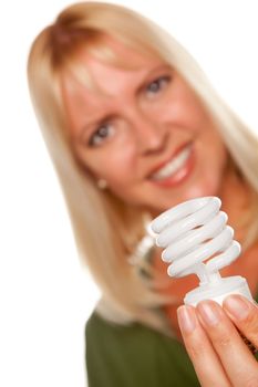 Attractive Blonde Woman Holds Energy Saving Light Bulb Isolated on a White Background with Narrow Depth of Field.