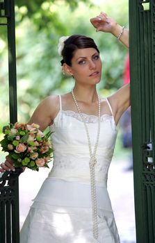 Half body portrait of beautiful young adult bride posing in doorway outside.