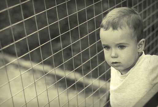 Urban child against the background of metal mesh