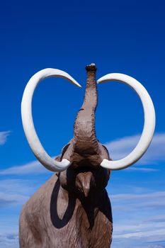 Sculpture of extinct woolly mammoth in aggressive pose.